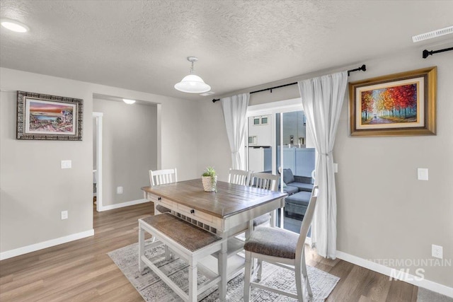 1266 S Wiston Ave, Kuna, ID 83634 - dining area with baseboards, a textured ceiling, and light wood finished floors
