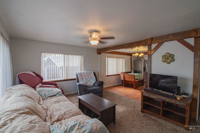 living room featuring vaulted ceiling with beams, a healthy amount of sunlight, wood-type flooring, and ceiling fan with notable chandelier