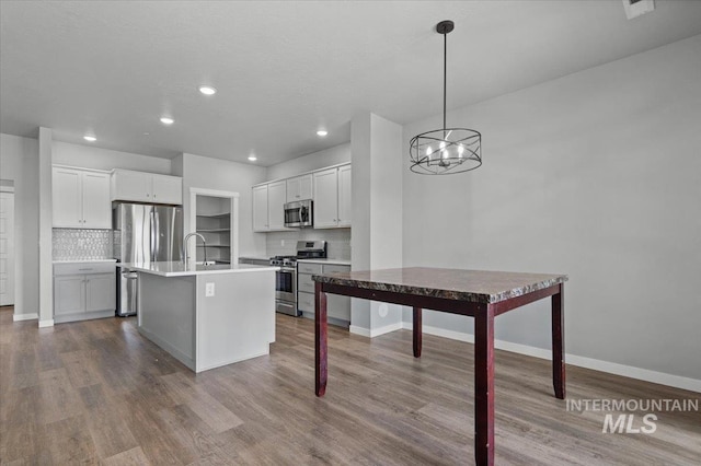 8450 S Bogus Ridge Ave, Boise, ID 83716 - kitchen featuring appliances with stainless steel finishes, decorative backsplash, wood finished floors, and recessed lighting