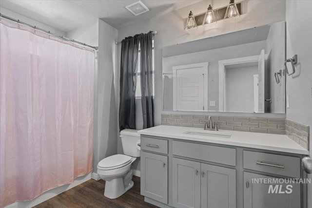 8450 S Bogus Ridge Ave, Boise, ID 83716 - full bath with toilet, vanity, decorative backsplash, and wood finished floors