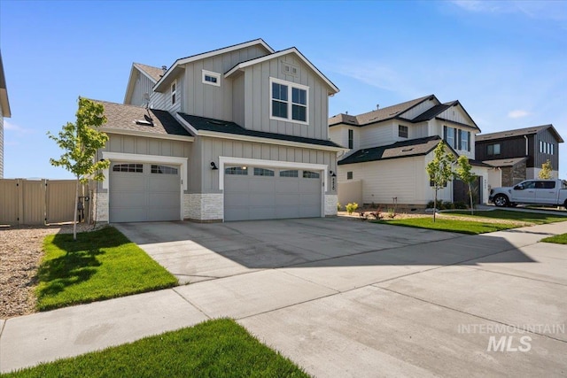 8450 S Bogus Ridge Ave, Boise, ID 83716 - view of front of property with board and batten siding, concrete driveway, stone siding, an attached garage, and a gate