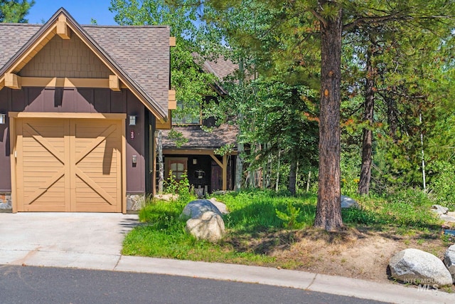 23 Golden Bar Ct, Donnelly, ID 83615 - view of front of house with a shingled roof, driveway, a garage, and board and batten siding