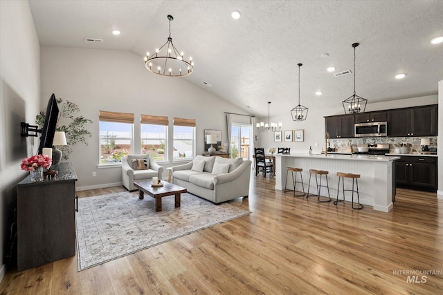 2188 Navigator St, Middleton, ID 83644 - living area with a chandelier, healthy amount of natural light, light wood-type flooring, recessed lighting, and high vaulted ceiling