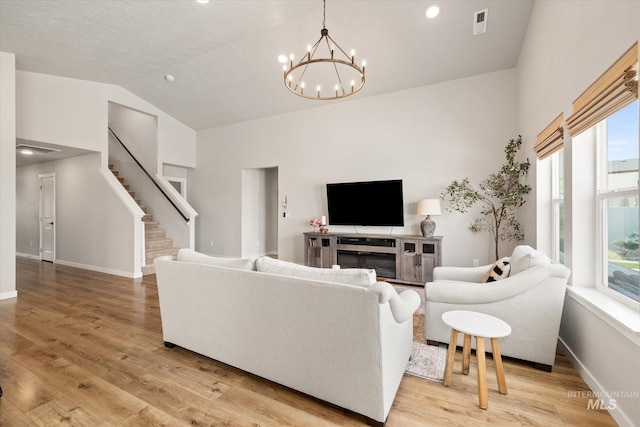 2188 Navigator St, Middleton, ID 83644 - living area with a chandelier, high vaulted ceiling, light wood-style floors, stairway, and recessed lighting