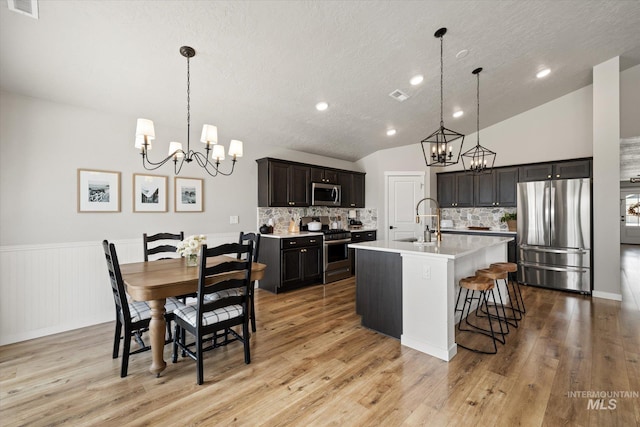 2188 Navigator St, Middleton, ID 83644 - kitchen with appliances with stainless steel finishes, a chandelier, light countertops, backsplash, and a textured ceiling