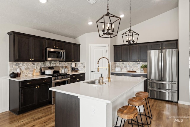2188 Navigator St, Middleton, ID 83644 - kitchen with stainless steel appliances, a textured ceiling, lofted ceiling, wood finished floors, and backsplash