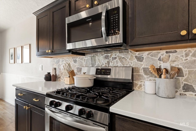 2188 Navigator St, Middleton, ID 83644 - kitchen with stainless steel appliances, dark brown cabinetry, a wainscoted wall, light countertops, and tasteful backsplash