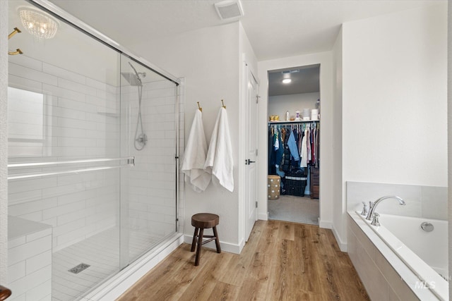 2188 Navigator St, Middleton, ID 83644 - full bath featuring a stall shower, wood finished floors, a bath, and a walk in closet
