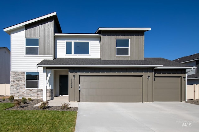 view of front facade with driveway, stone siding, a garage, and board and batten siding