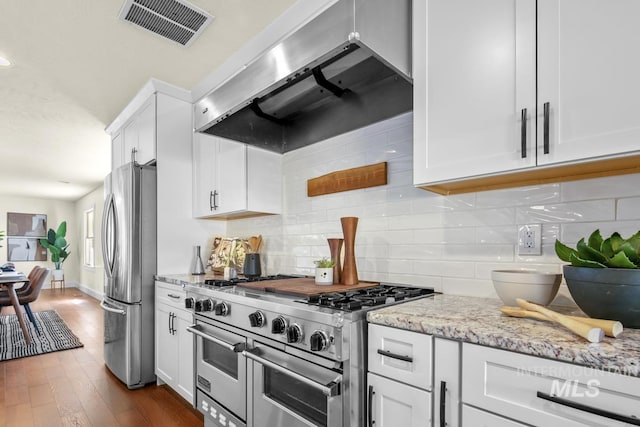 kitchen featuring extractor fan, white cabinets, visible vents, light stone countertops, and appliances with stainless steel finishes