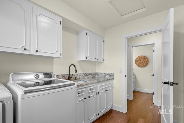 laundry room featuring a sink, cabinet space, dark wood-type flooring, separate washer and dryer, and baseboards