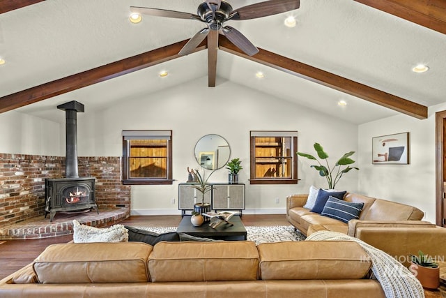 living room featuring a ceiling fan, recessed lighting, baseboards, wood finished floors, and a wood stove