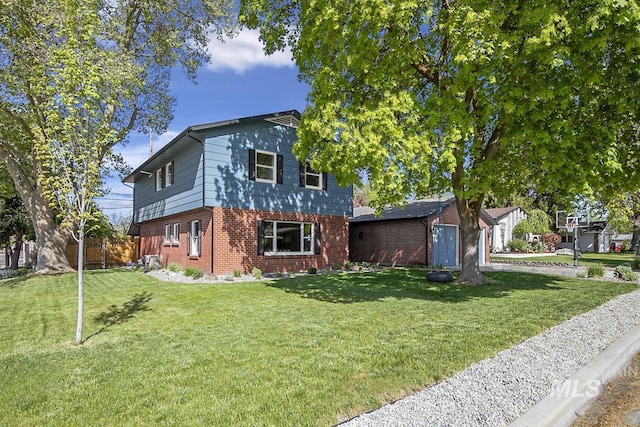 view of front of property with fence, brick siding, and a front yard