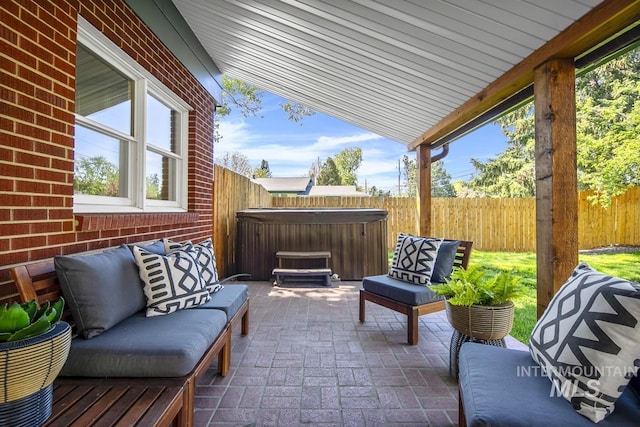 view of patio featuring a hot tub and a fenced backyard