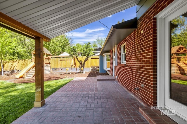 view of patio with a fenced backyard and a playground