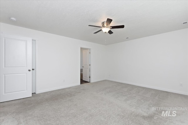 unfurnished room with ceiling fan, light colored carpet, and a textured ceiling