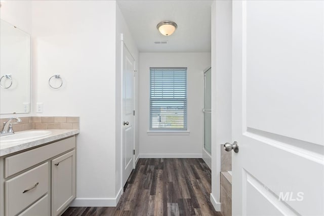 bathroom featuring vanity, wood-type flooring, and walk in shower