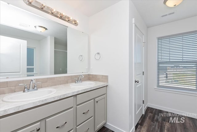 bathroom featuring hardwood / wood-style flooring, vanity, and tasteful backsplash