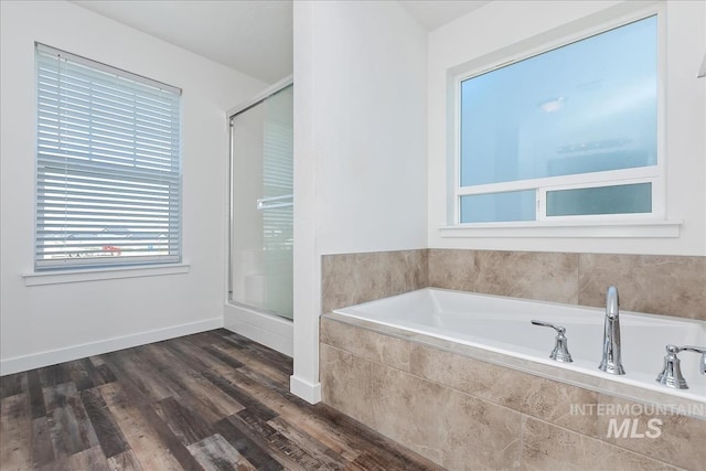 bathroom with hardwood / wood-style flooring and independent shower and bath