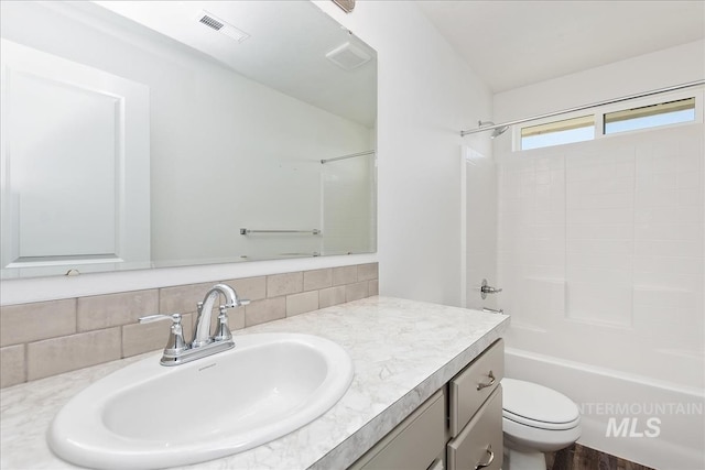 full bathroom with vanity, toilet, washtub / shower combination, and tasteful backsplash