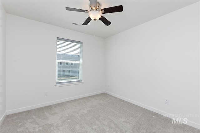 carpeted spare room with ceiling fan