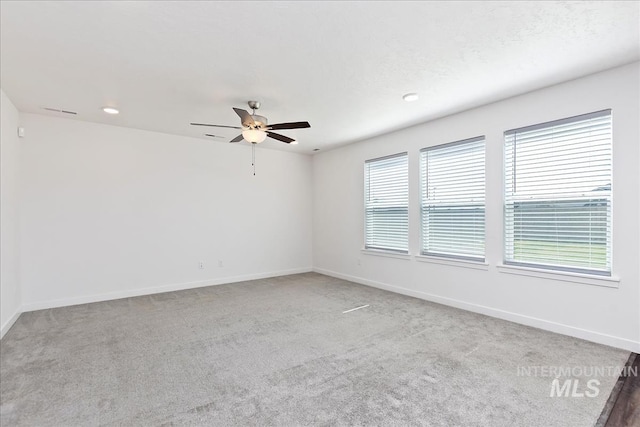 carpeted spare room featuring ceiling fan