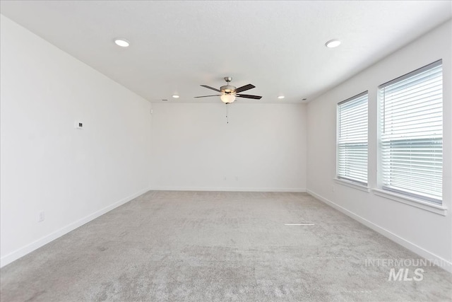 spare room with ceiling fan and light colored carpet