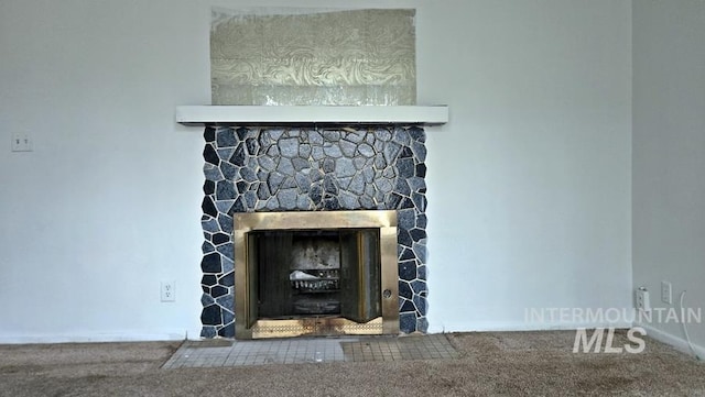 interior details featuring carpet flooring and a stone fireplace