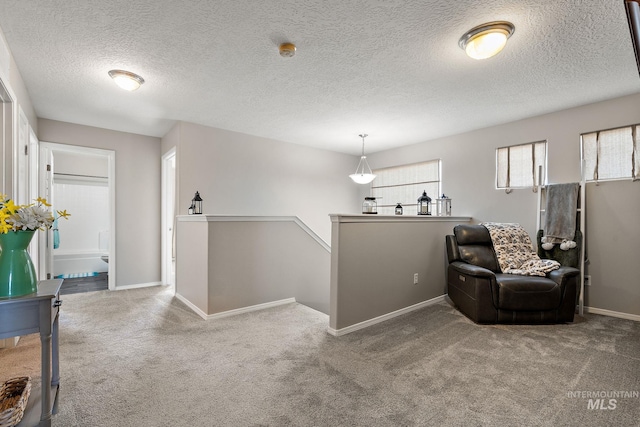 living area featuring an upstairs landing, carpet flooring, and baseboards