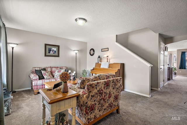 living room featuring baseboards, carpet, and a textured ceiling