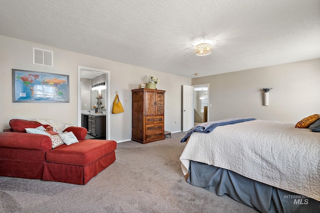 carpeted bedroom with visible vents, baseboards, a textured ceiling, and connected bathroom