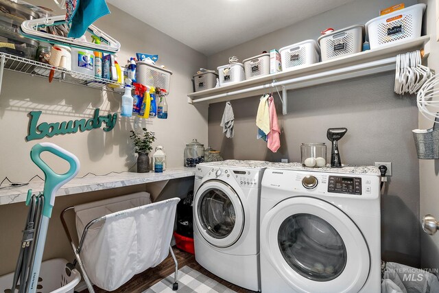 laundry room with wood finished floors, washing machine and dryer, and laundry area