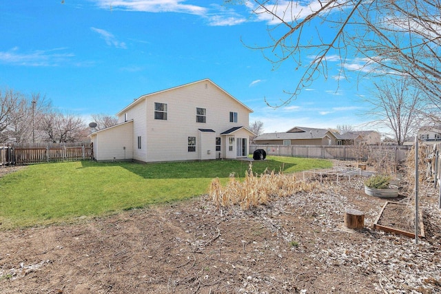 rear view of property with a fenced backyard, a lawn, and a vegetable garden