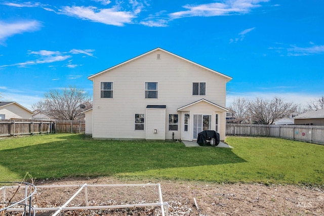 back of house featuring a yard and a fenced backyard