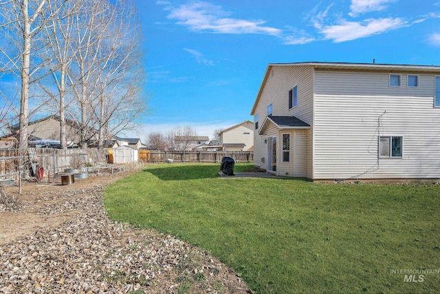 view of yard featuring an outdoor structure, a storage unit, and a fenced backyard