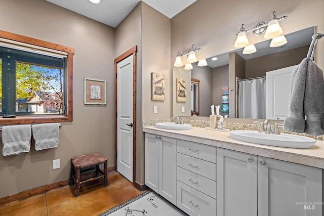 306 Otter Pond Ln, Mccall, ID 83638 - bathroom featuring double vanity, a sink, baseboards, and finished concrete floors