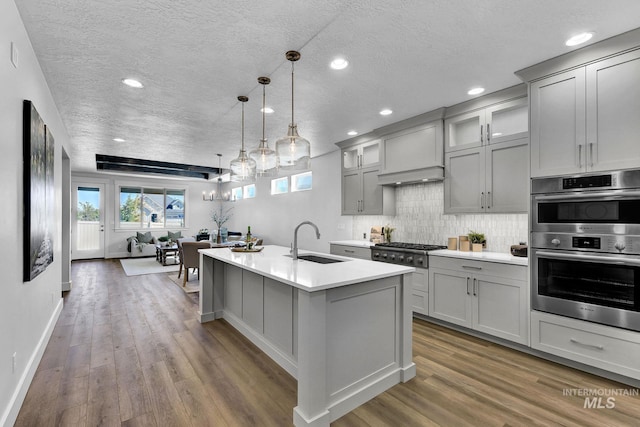 6318 S Utmost Ln, Meridian, ID 83642 - kitchen with appliances with stainless steel finishes, gray cabinetry, light countertops, wood finished floors, and a textured ceiling