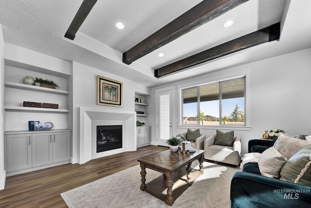 6318 S Utmost Ln, Meridian, ID 83642 - living area featuring built in shelves, a textured ceiling, a glass covered fireplace, dark wood-style flooring, and recessed lighting