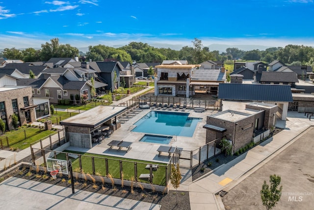 community pool with a residential view, a patio, and fence