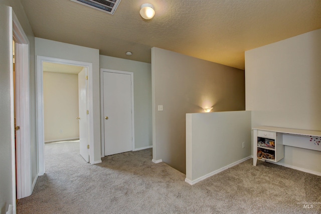 corridor featuring baseboards, visible vents, and carpet
