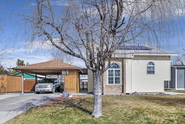 view of front of home with driveway, fence, and a front lawn