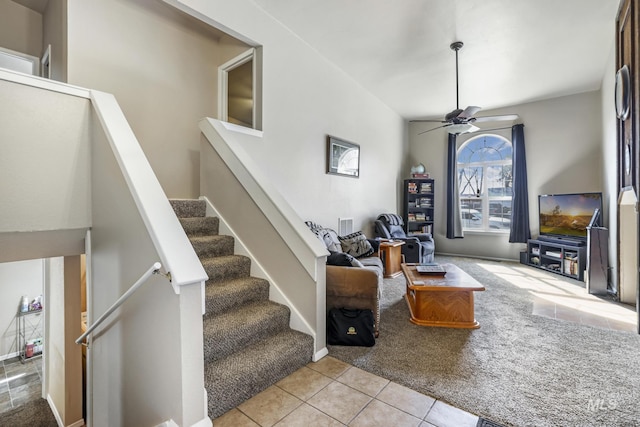 carpeted living room featuring a ceiling fan, tile patterned flooring, visible vents, and stairway