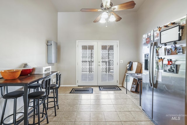 kitchen with light tile patterned floors, baseboards, french doors, and stainless steel fridge with ice dispenser