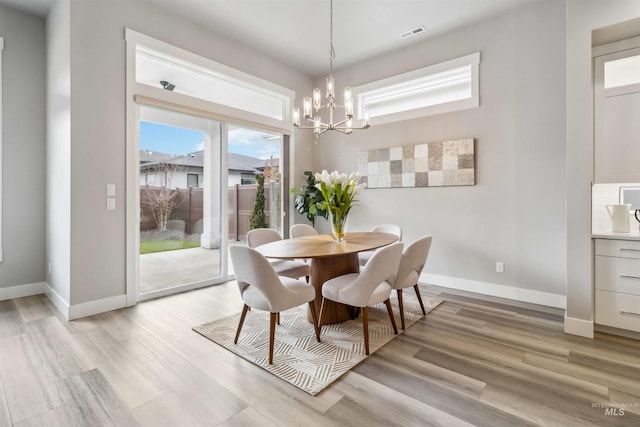 dining area featuring a notable chandelier and light hardwood / wood-style flooring