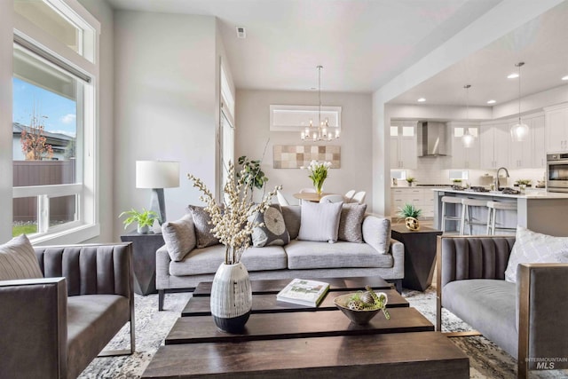 living room with a notable chandelier, a healthy amount of sunlight, and sink