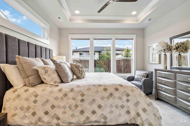 carpeted bedroom featuring ceiling fan, a raised ceiling, and access to exterior