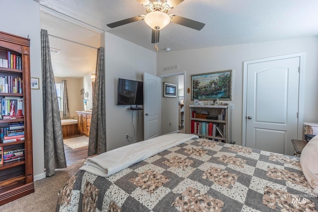 bedroom with carpet floors, lofted ceiling, visible vents, ensuite bathroom, and a textured ceiling