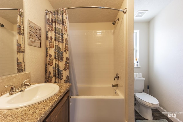 bathroom featuring visible vents, toilet, vanity, a textured ceiling, and shower / bath combination with curtain