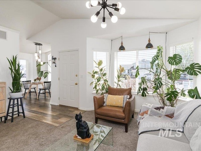 5287 Stuart Ave, Chubbuck, ID 83202 - living area featuring a chandelier, vaulted ceiling, carpet floors, and wood finished floors