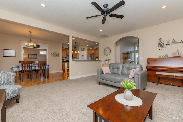 818 W Dallan Woods Way, Nampa, ID 83686 - living room with light colored carpet, arched walkways, ceiling fan, recessed lighting, and a chandelier